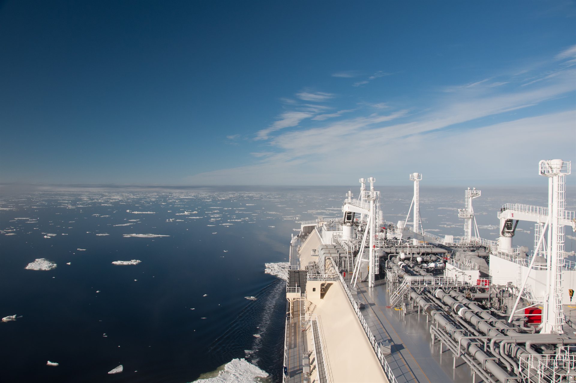 LNG carrier crossing Arctic ice floes under clear blue sky